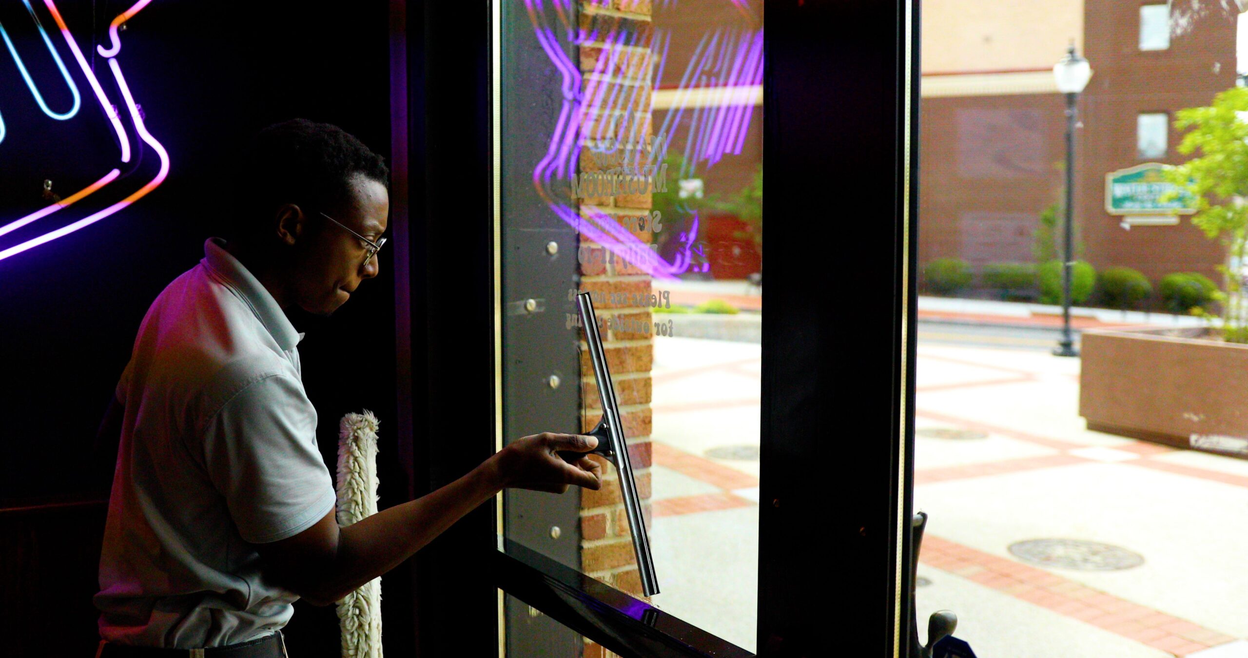 A Window Ninjas Charlotte expertly cleaning the inside of a business's storefront windows.