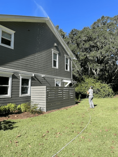 A Window Ninjas professional cleaning the soffit and roof of a residential home - we offer the best Charleston roof cleaning services.