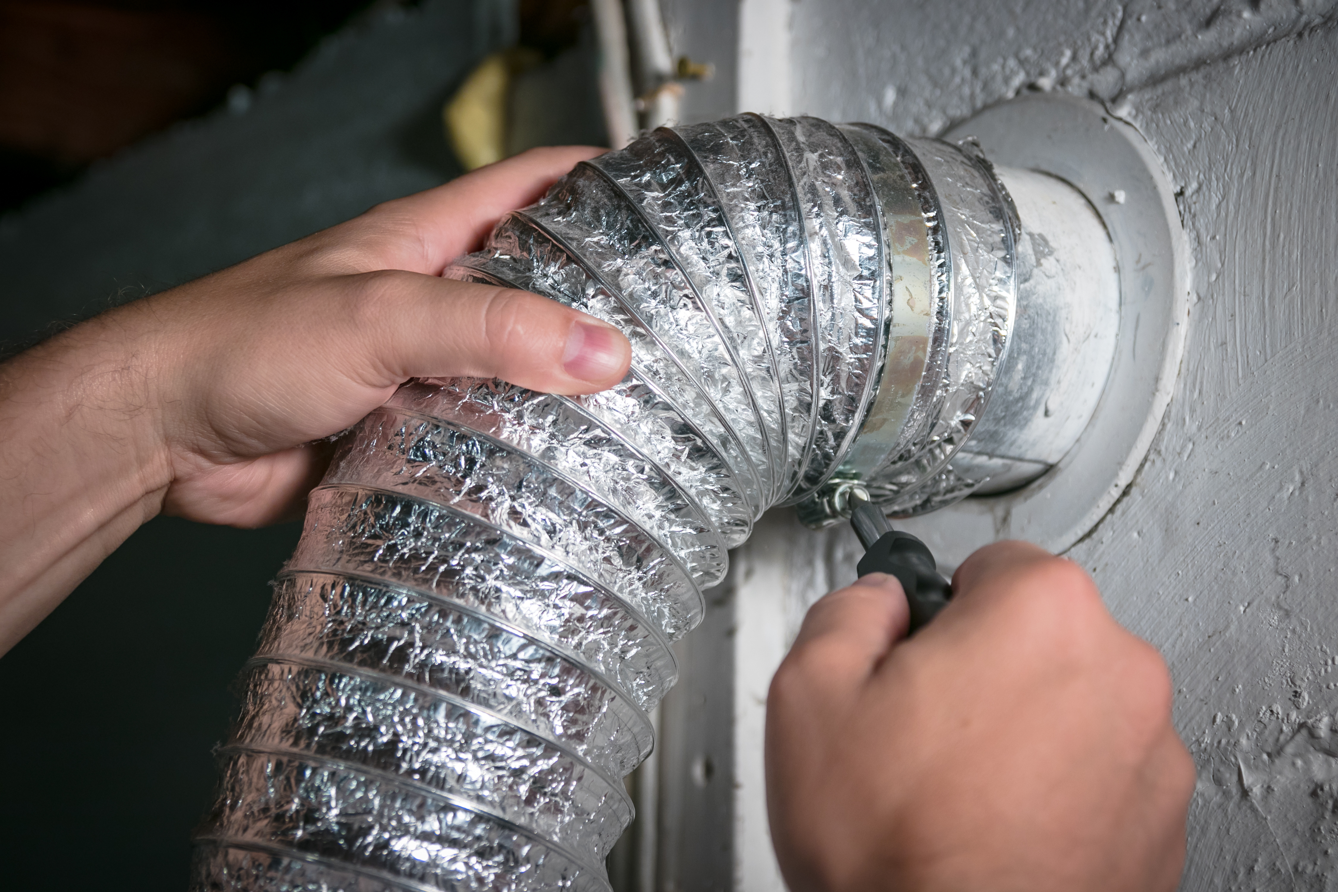 A close up of a Window Ninjas Wilmington technician cleaning a dryer vent - if you are in need of services for dryer vent cleaning condominium in Wilmington, NC, contact us today!