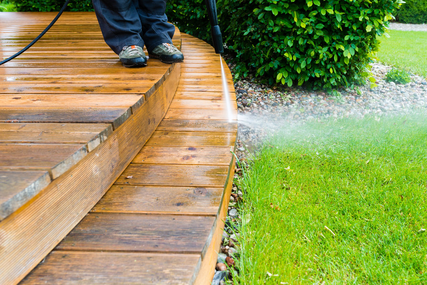 A Window Ninjas pressure washing technician providing soft window washing services for a deck.