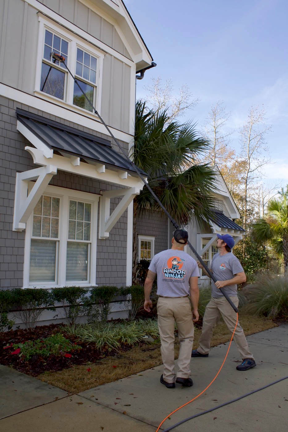 Two Window Ninjas Nashville technicians cleaning high windows - contact us today to begin your career with us!