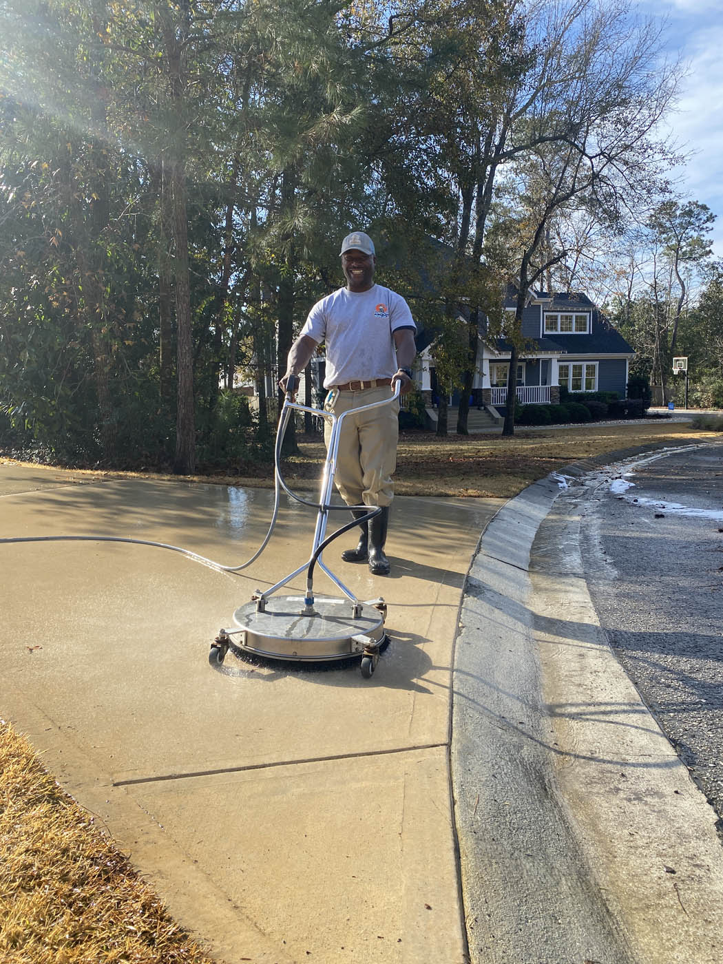 A Window Ninjas Richmond power washing expert providing cleaning services for the driveway of a residential home.