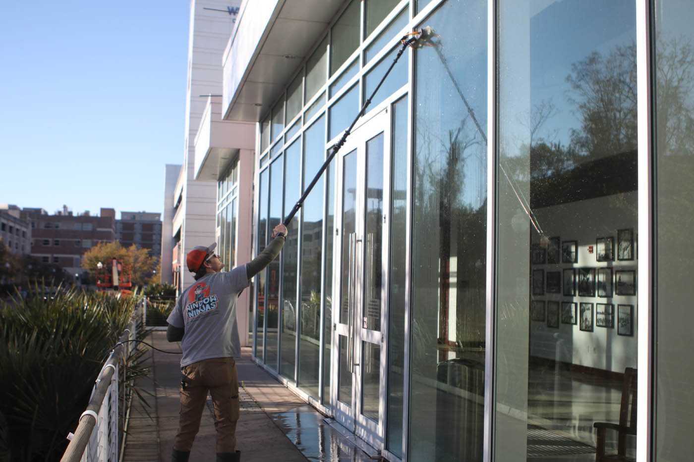 A Window Ninjas washer cleaning the outside of a commercial building - trust our experts for the best window cleaning in New Kent, VA.