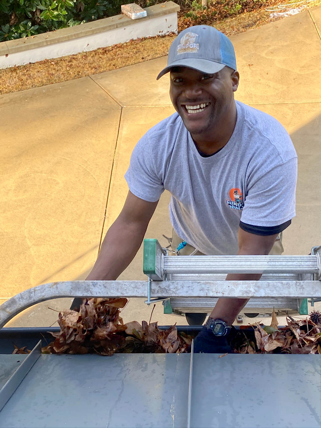 A Window Ninjas Nashville professional cleaning out the gutters for a home.