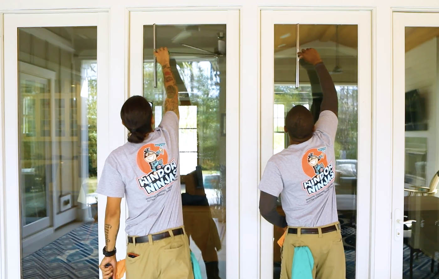 Two Window Ninjas professionals washing windows - explore our wide range of services including window cleaning in Disputanta, VA.