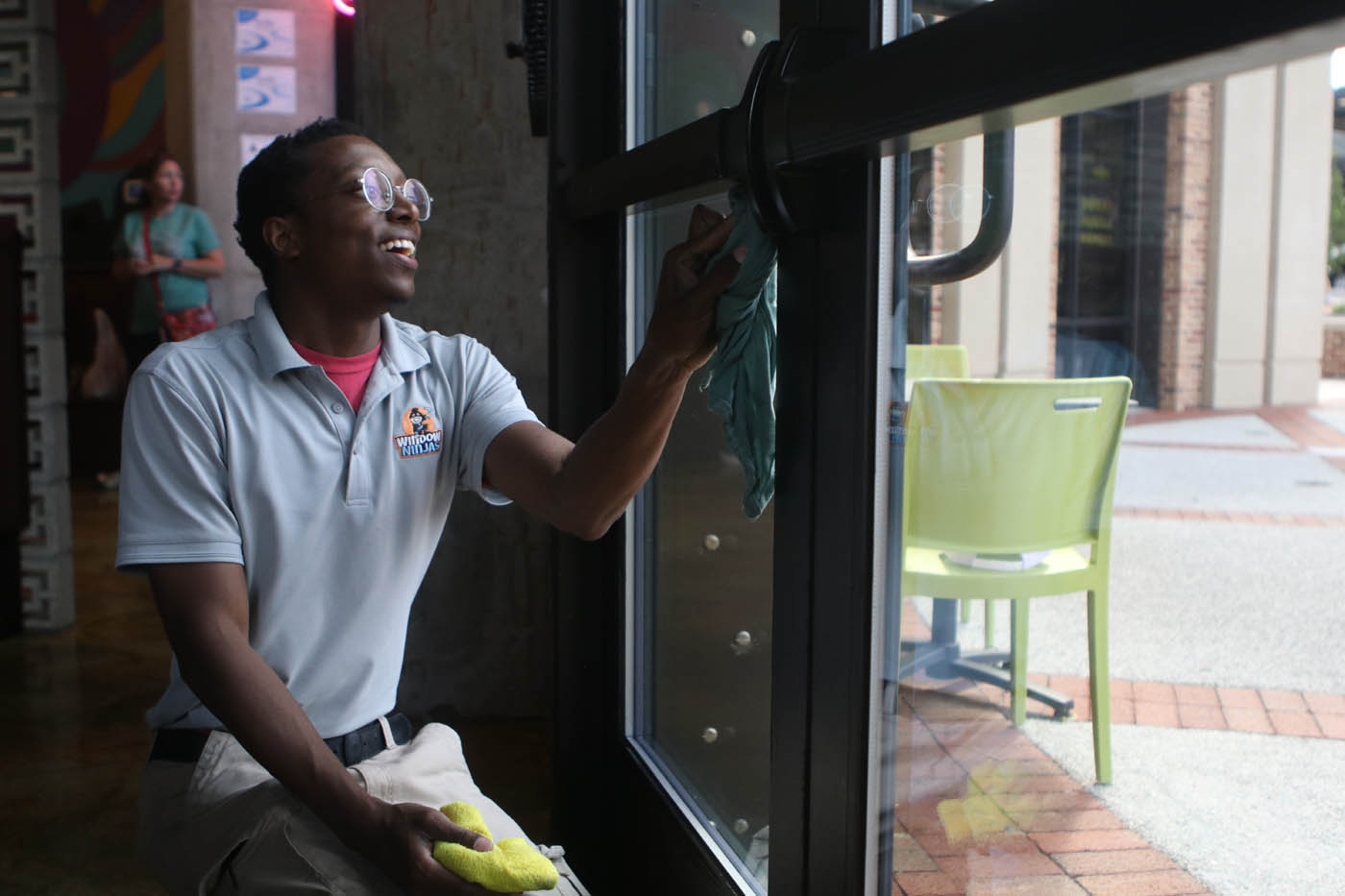 A Window Ninjas Greenville / Spartanburg window technician cleaning the inside windows for a commercial property.