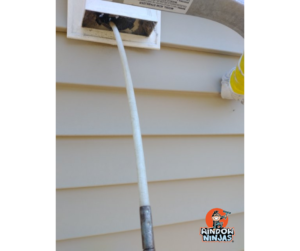 Dryer Vent Cleaning tool entering an exterior dryer vent