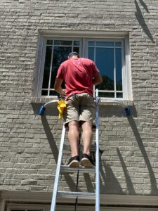 cleaning windows on ladder